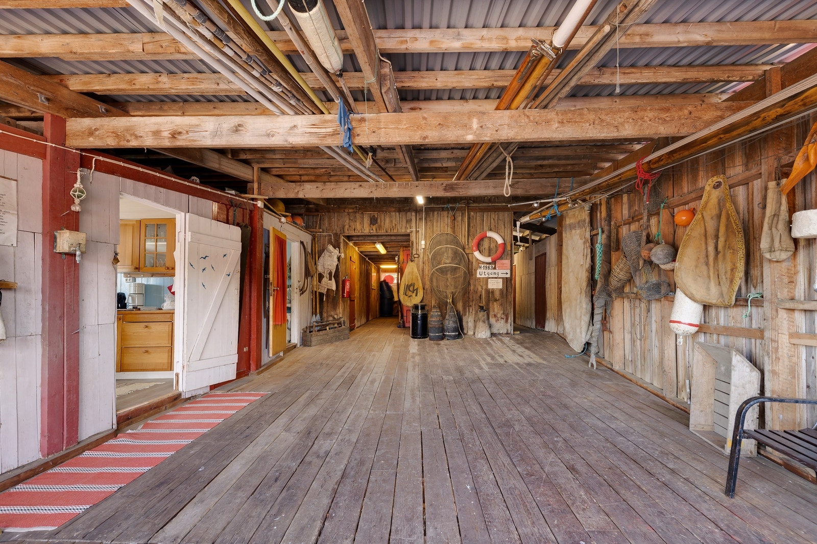 På veggene henger gamle fiskeredskaper, fotografier i sort-hvitt og annet båtutstyr. Galleribilde