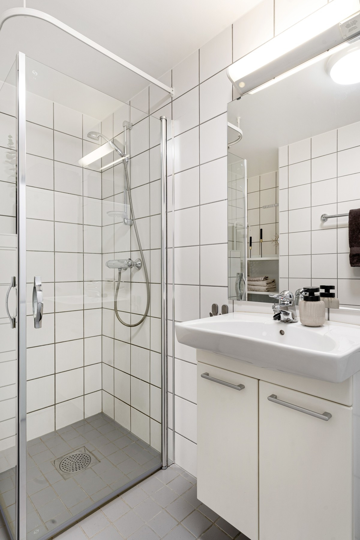 Badet har opplegg for vaskemaskin, plass til tørketrommel og servant med underskap.