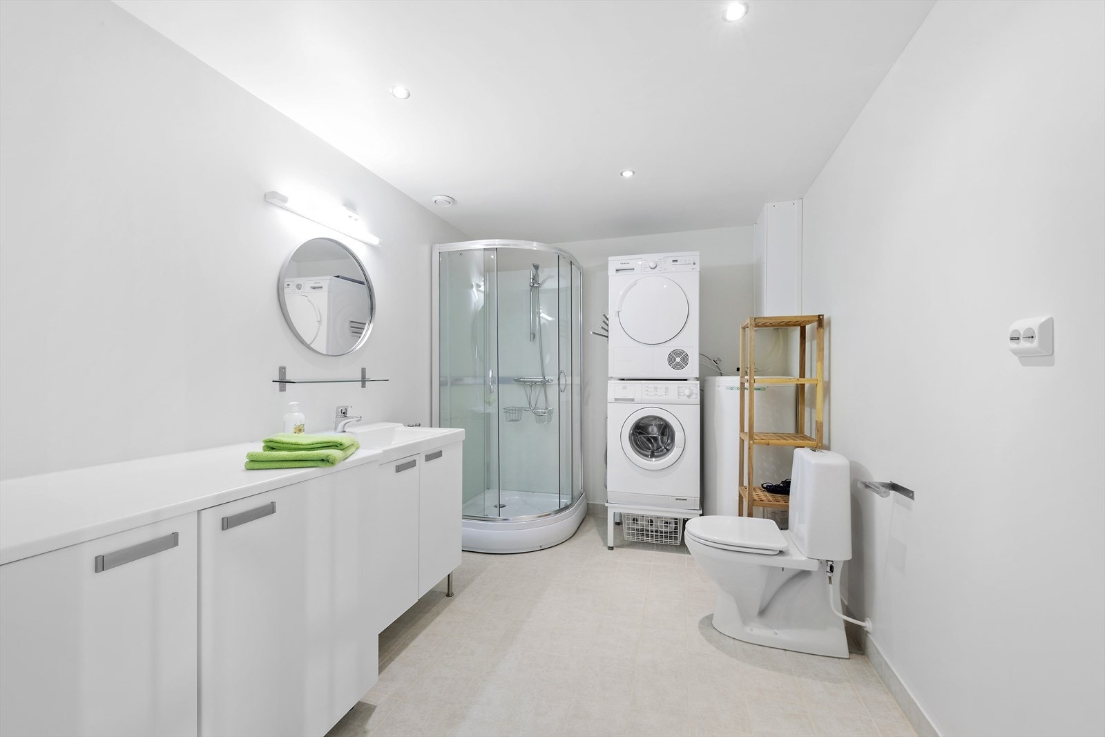 Romslig bad med gode oppbevaringsløsninger og opplegg for vaskemaskin i underetasjen. Galleribilde