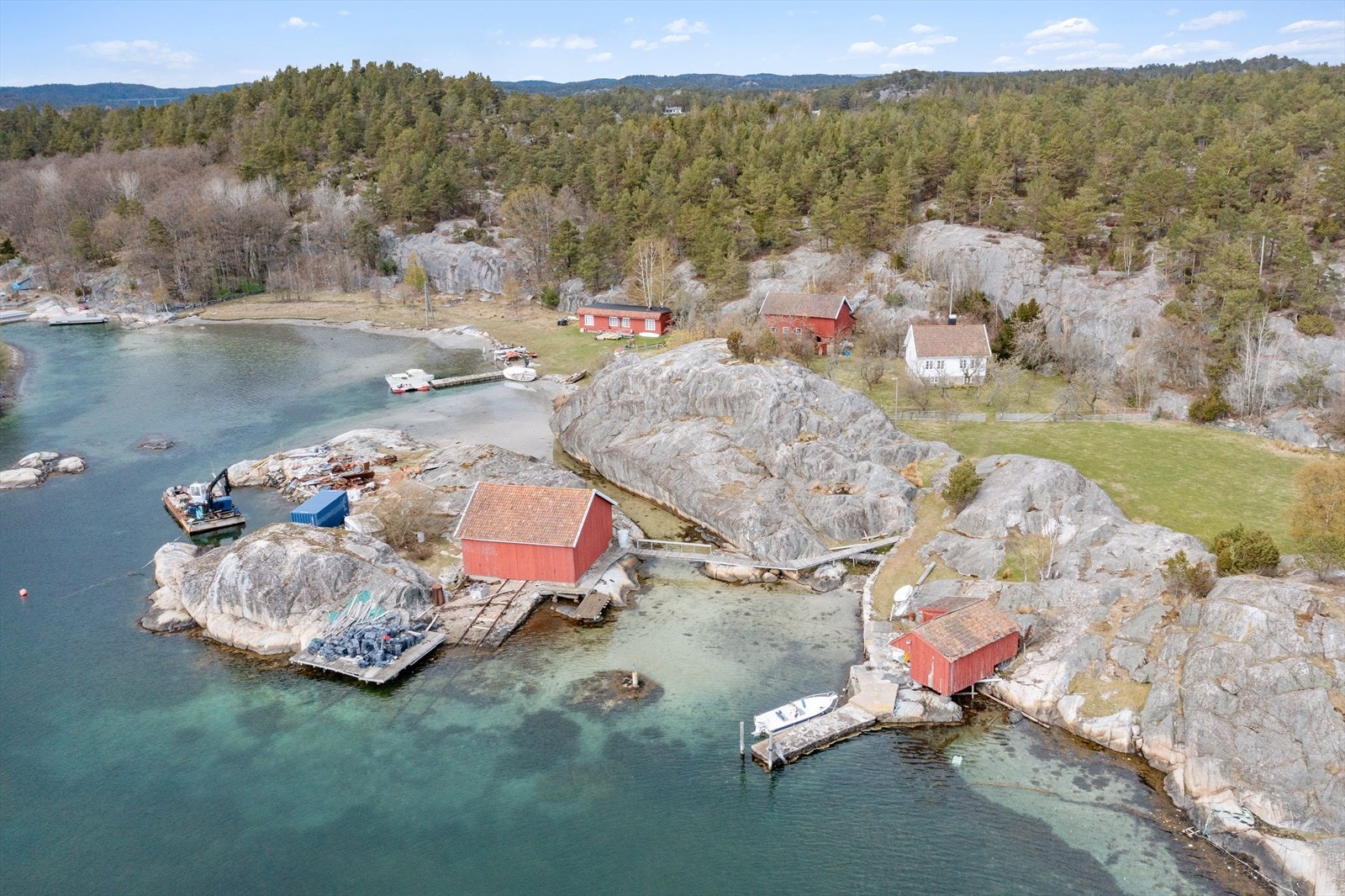 På bilde sees hovedhuset, låven, hytta og den minste sjøbua, samt båthuset med slipp Galleribilde