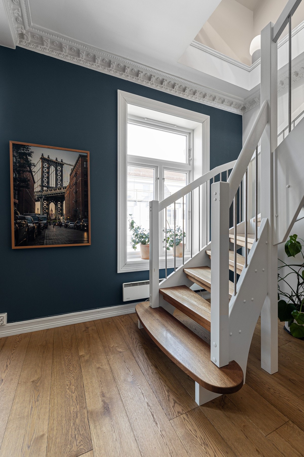 Mellom etasjene er det en hvitmalt, åpen tretrapp med heltre trappetrinn, som fører rett opp til stue og kjøkken i loftetasjen. Galleribilde