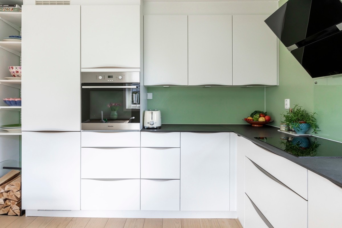Lekkert, matt hvitt kjøkken med alle hvitevarer integrerte. Galleribilde