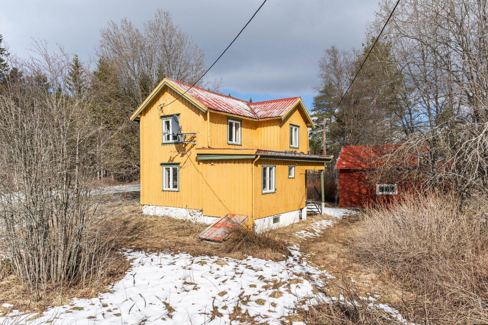 Boligens fasade sammen med kjellernedgang og garasjen Galleribilde