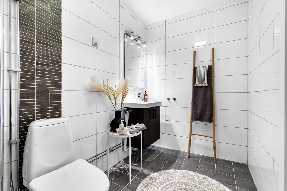 Badet er utstyrt med heldekkende servant over skap, ettgreps blandebatteri, speil og ekstra belysning. Galleribilde