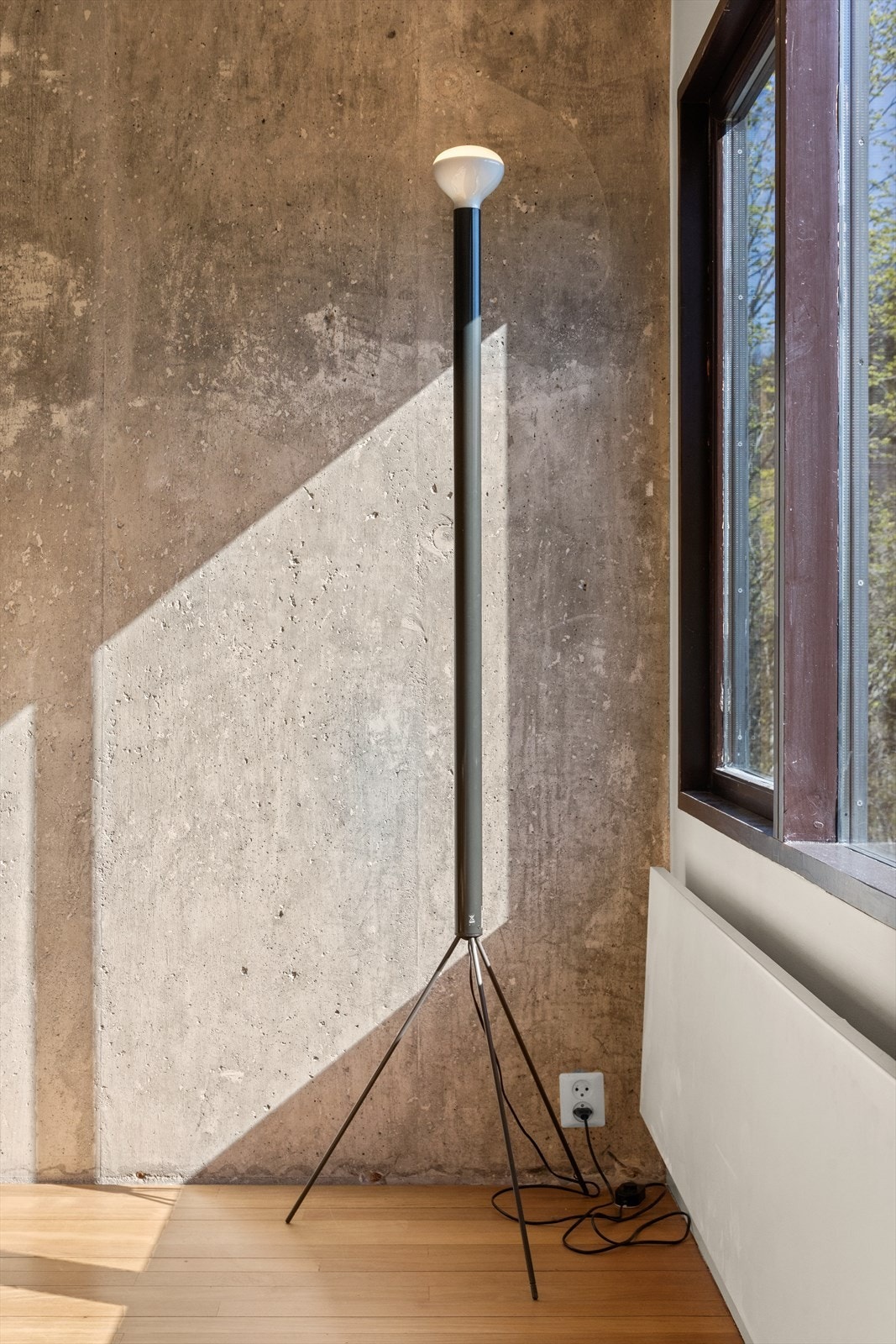 Den store betongveggen sammen med det originale tregulvet gir en harmonisk helhet til spisestuen. Galleribilde