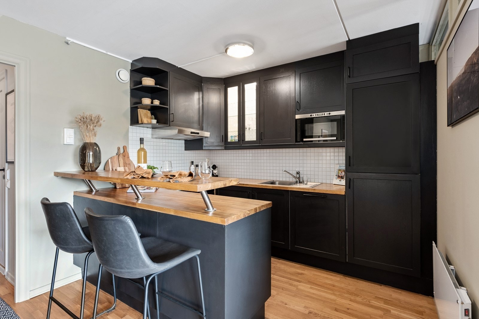 Barløsningen fungerer både som en koselig spiseplass, og som en naturlig romdeler mellom kjøkken og stue. Galleribilde