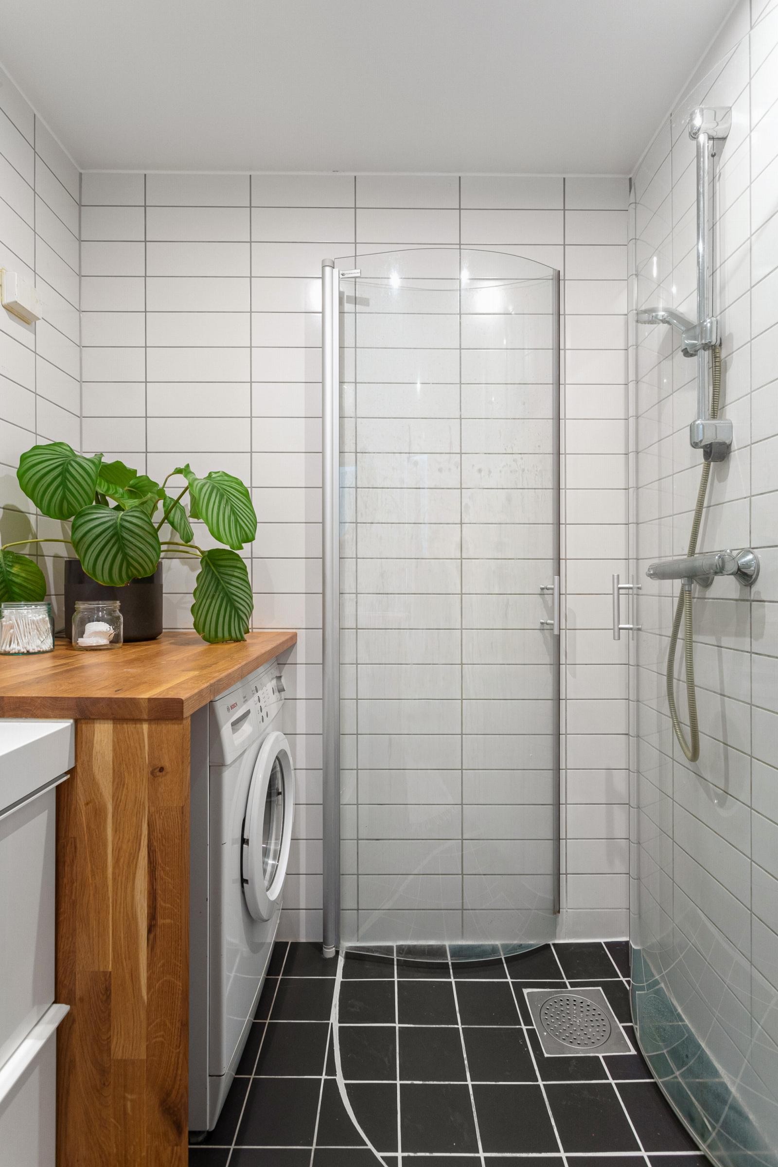 Badet består av dusjhjørne, vegghengt toalett, servant med underskap og opplegg for vaskemaskin. Galleribilde