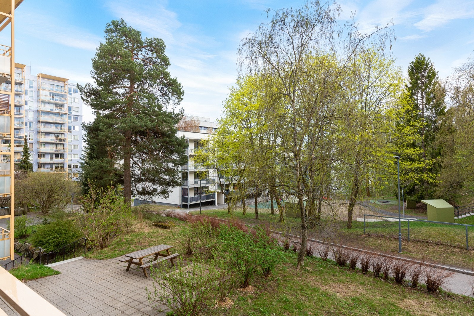 Hyggelig utsyn fra balkongen mot borettslagets pent opparbeidede fellesarealer. Galleribilde