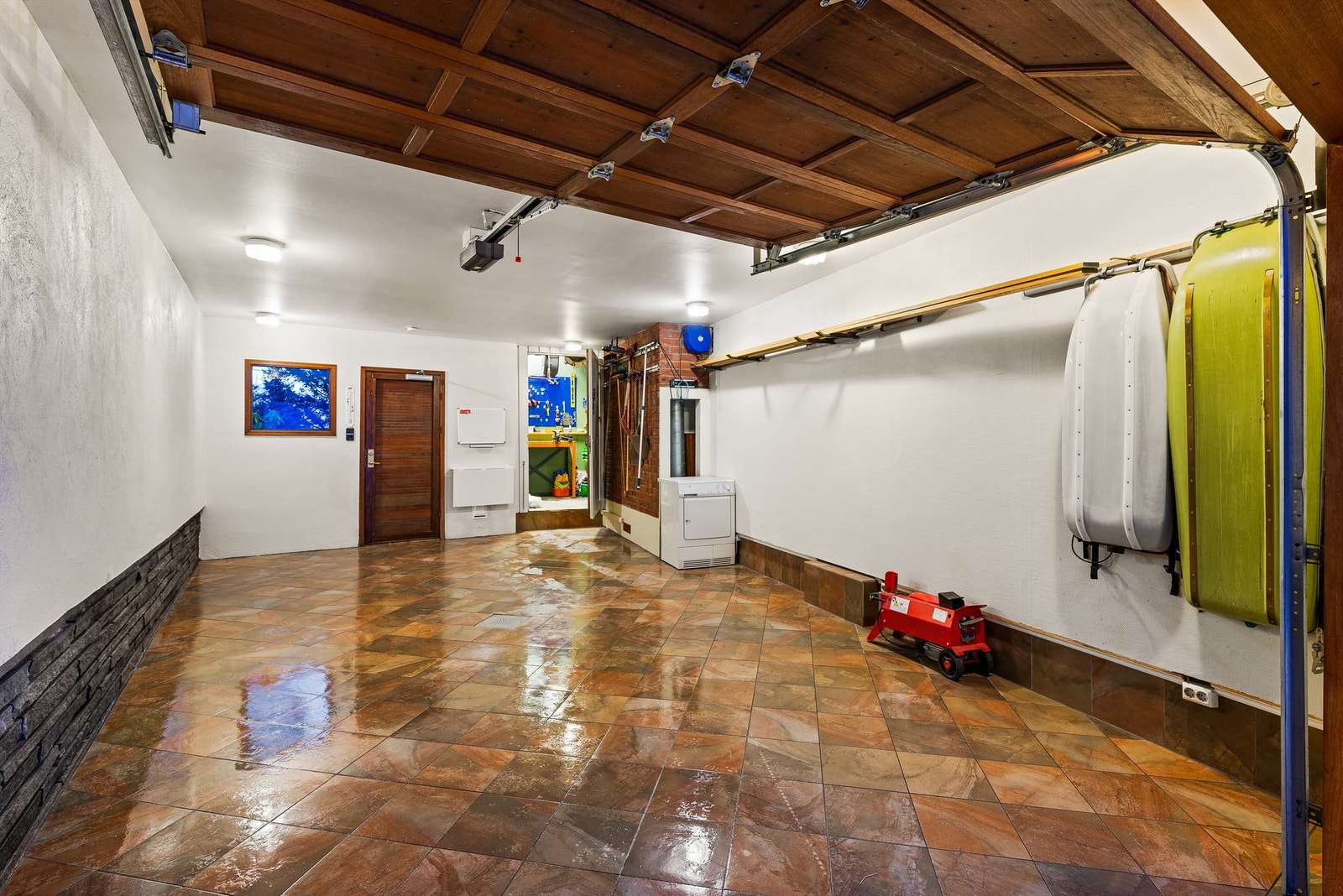 Begge garasjene har flislagte gulv og motoriserte porter. Galleribilde