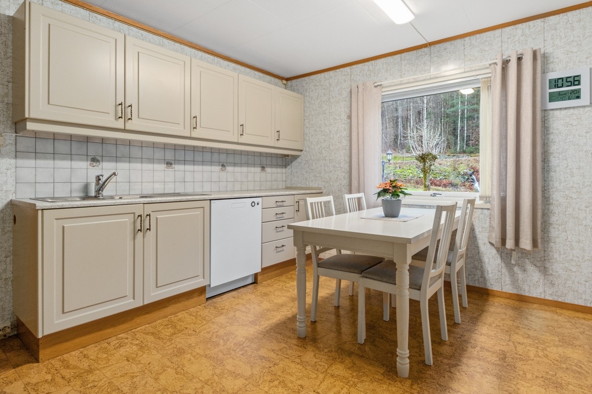 Eldre plassbygd kjøkken med avsatt plass til oppvaskmaskin, komfyr og kjøleskap som medfølger Galleribilde