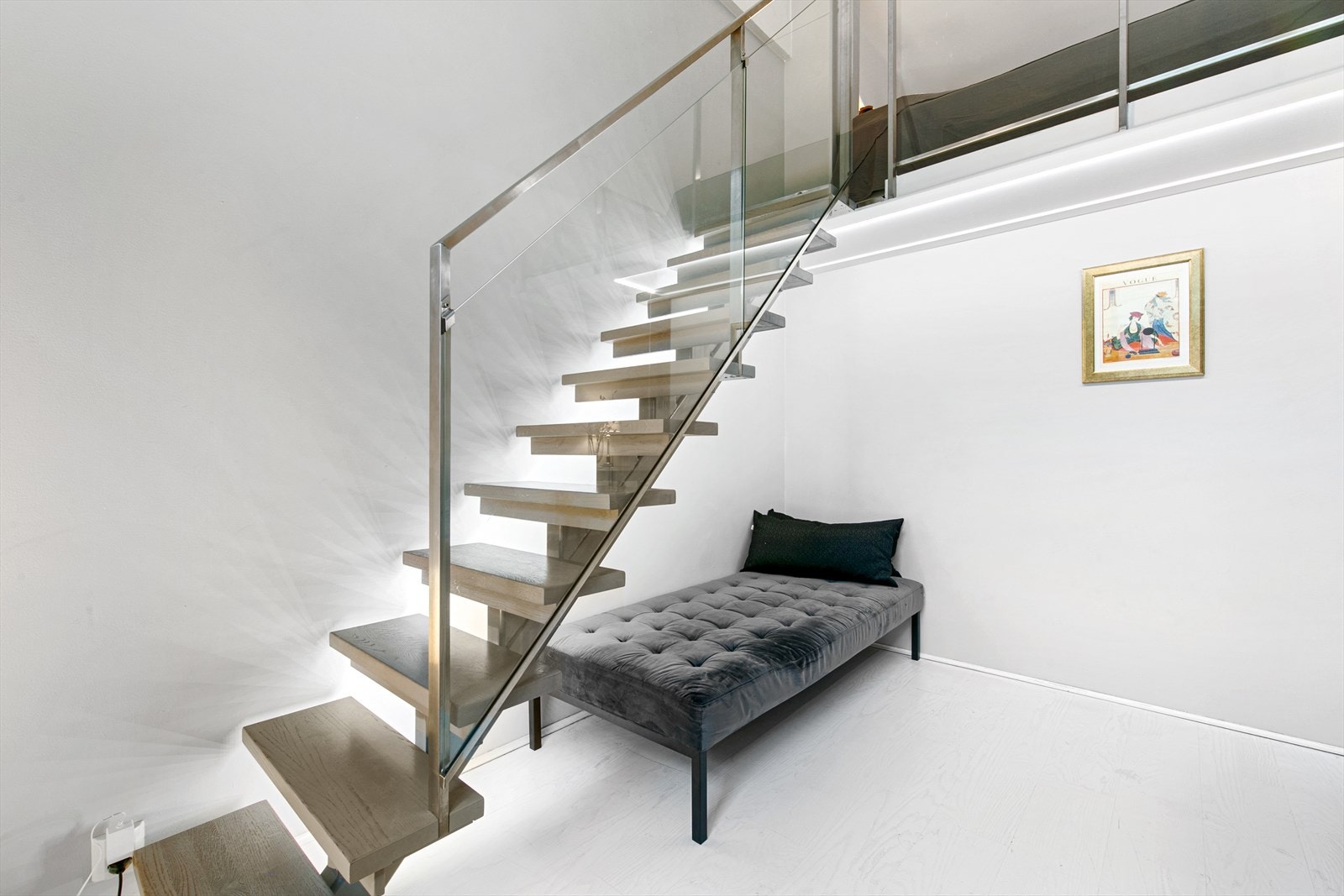 Kunst? Skulptur? Dette er trappen, med glassrekkverk, som leder opp til mesanin innredet med seng Galleribilde