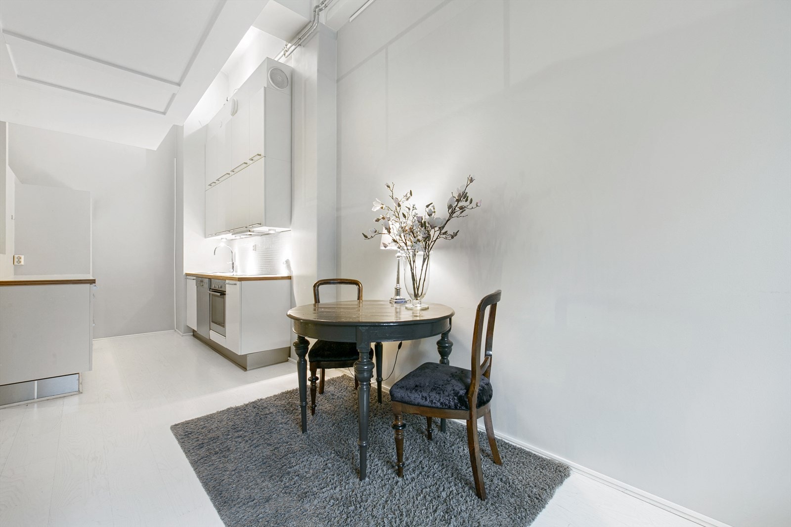 Spiseplass mellom kjøkken og stue i den åpne og luftige planløsningen Galleribilde