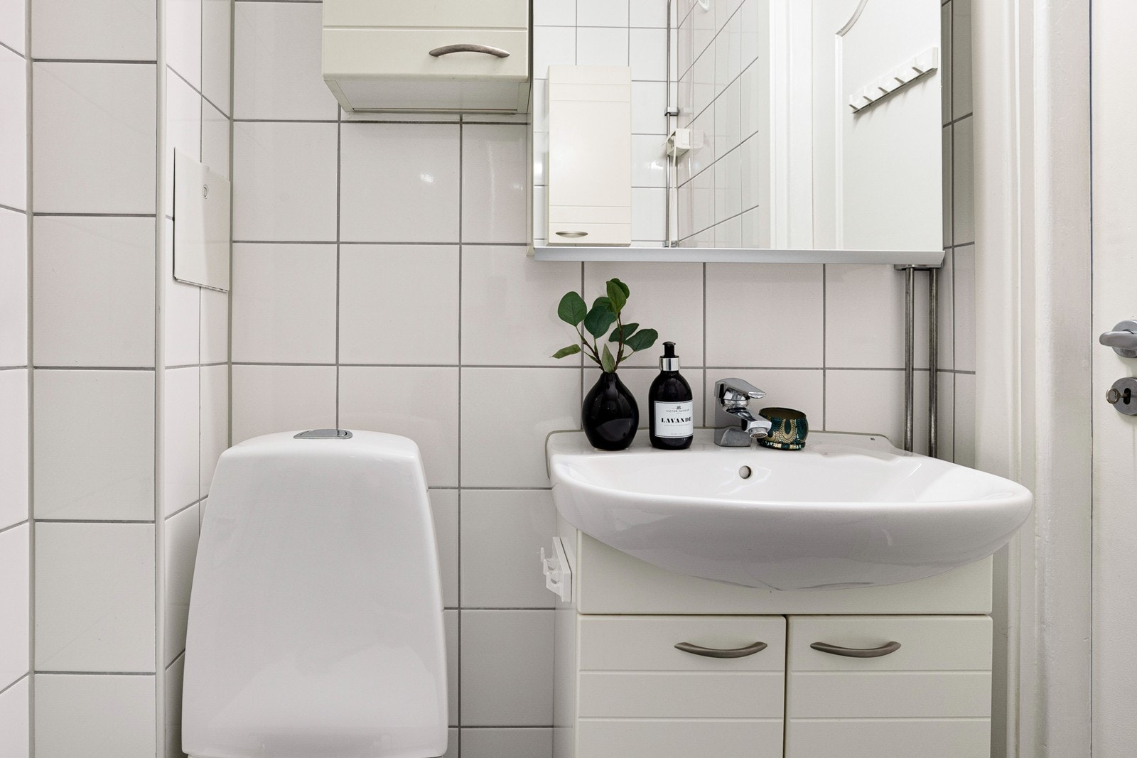 Dusj med innfellbare dører i glass, toalett, servantinnredning, opplegg for vaskemaskin og varmekabler i gulv. Galleribilde