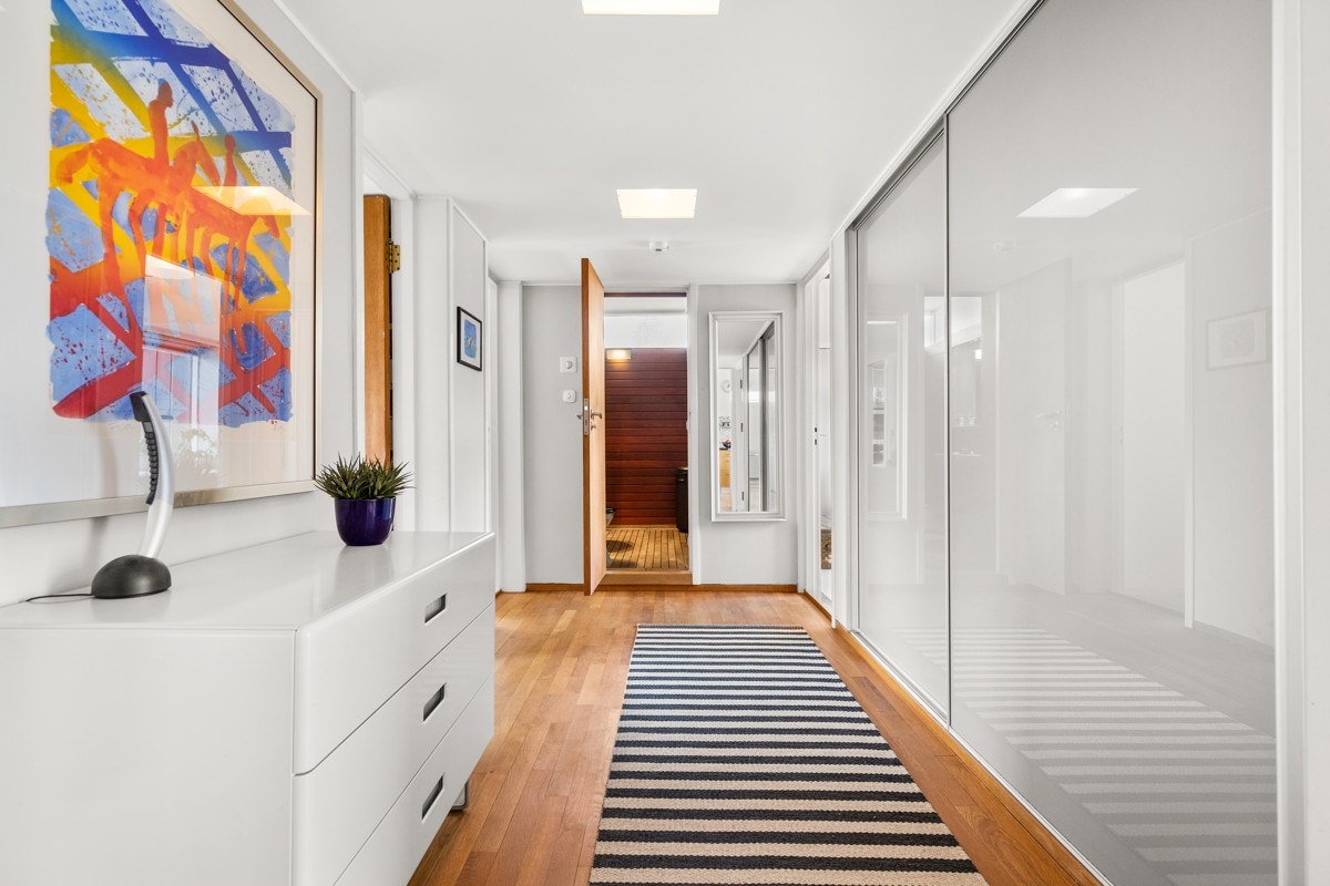 Mellomgang med stor og praktisk skyvedørsgarderobe langs den ene veggen Galleribilde