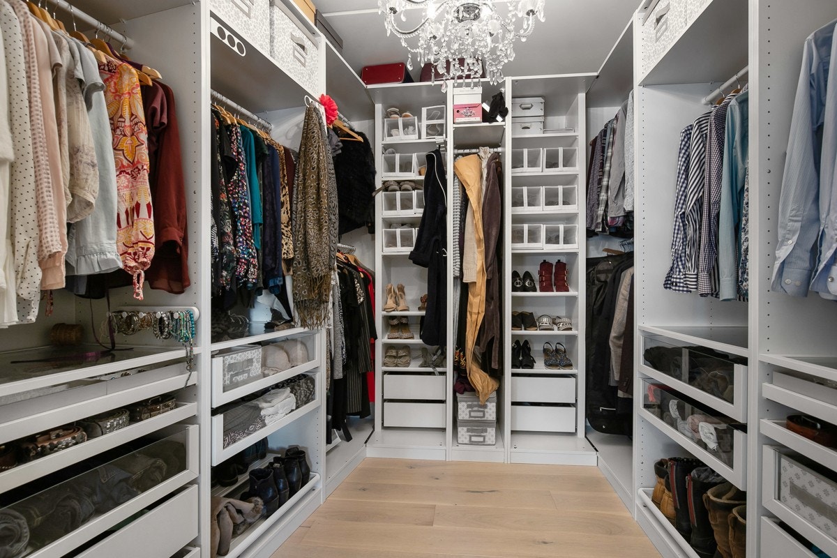 Garderoberommet har en innholdsrik innredning med åpne skapstammer, hyller, skuffer og heng. Galleribilde