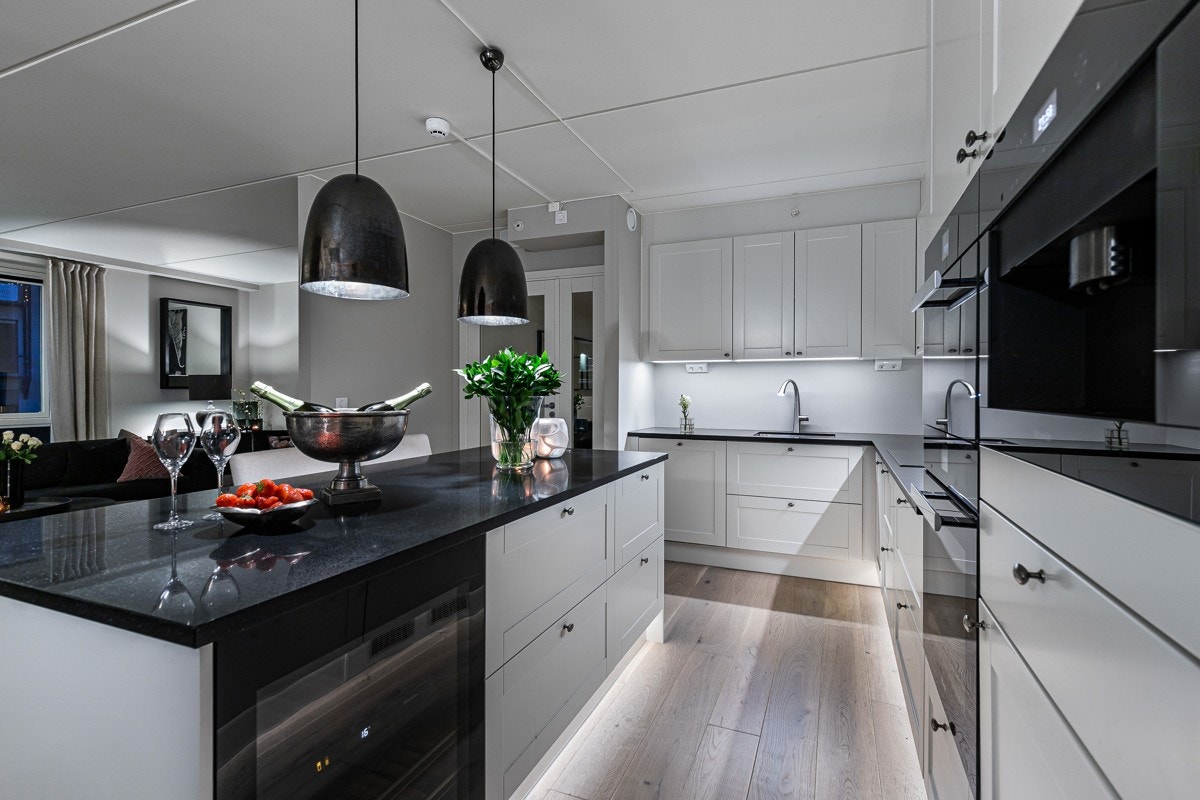 Innredningen har hvite rammefronter, benkebelysning og benkeplate med underlimt kum i stål. Galleribilde