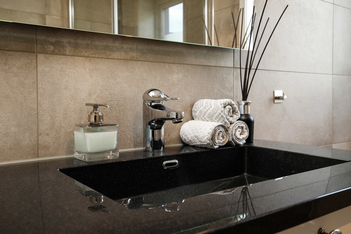 Begge badene har delikate fliser i en gråbeige farge. Galleribilde