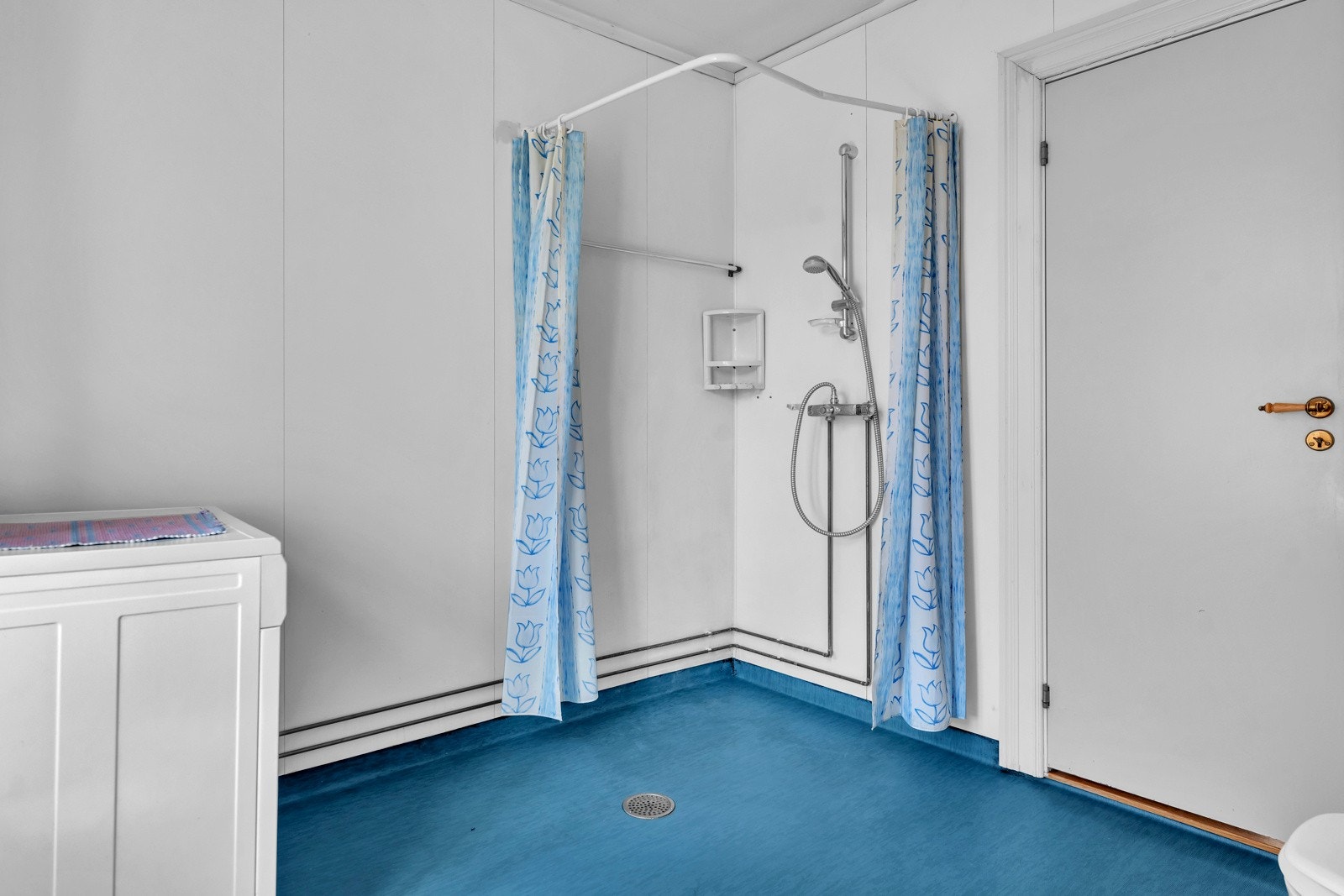 Badet er utstyrt med vegghengt servant med ett-greps armatur, speilskap og overlys med stikkontakt på vegg over servant Galleribilde