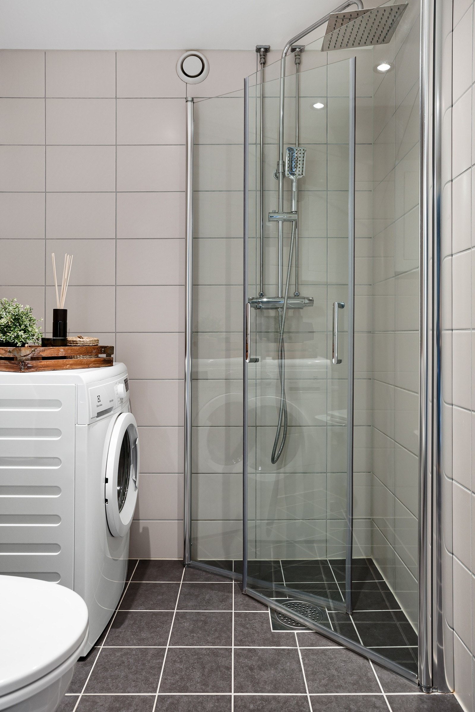 Badet er praktisk med opplegg for vaskemaskin og dusjnisje i hjørne med innfellbare glassdører. Himlingen er senket med malt flate og downlights. Gulv og vegger er flislagt, og det er varmekabler. Galleribilde