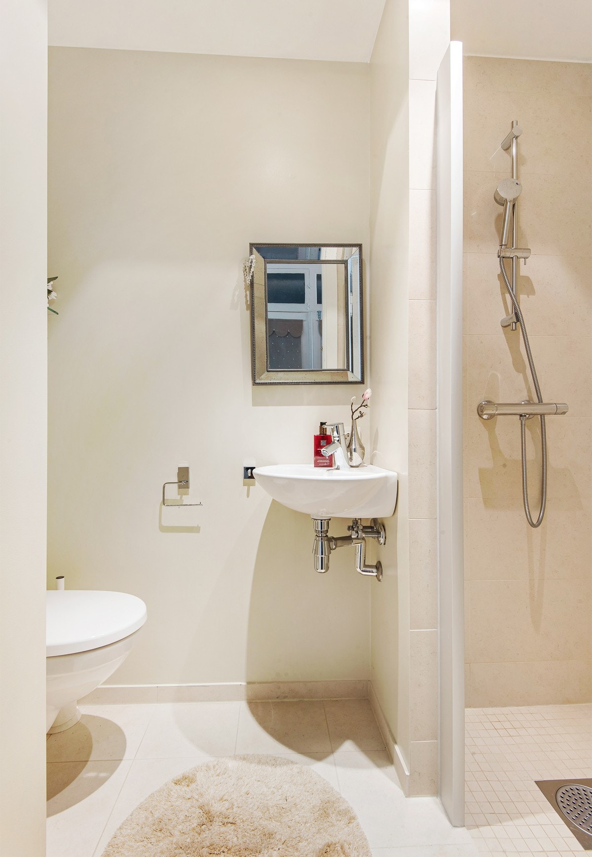 Stilrent baderom nr 2 utstyrt med vegghengt toalett og regnfallsdusj. Praktisk tilgang fra entré Galleribilde