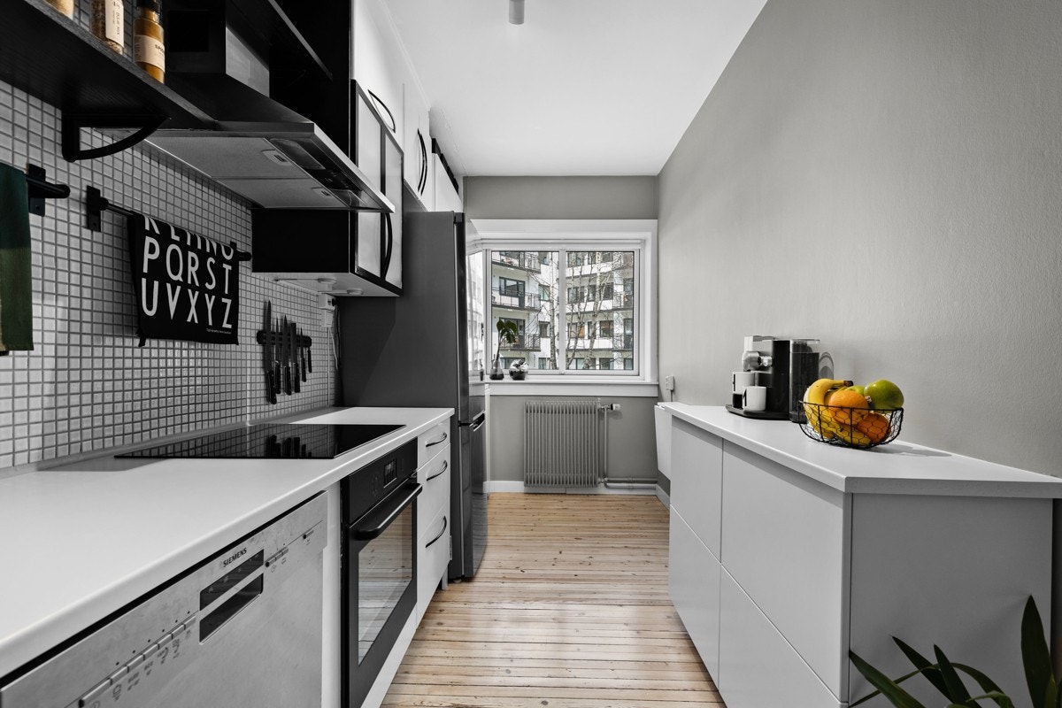 Kjøkkeninnredningen består av hvite glatte fronter samt overskap med frostet glass, laminat benkeplate med skyllekum og ettgreps blandebatteri. Galleribilde