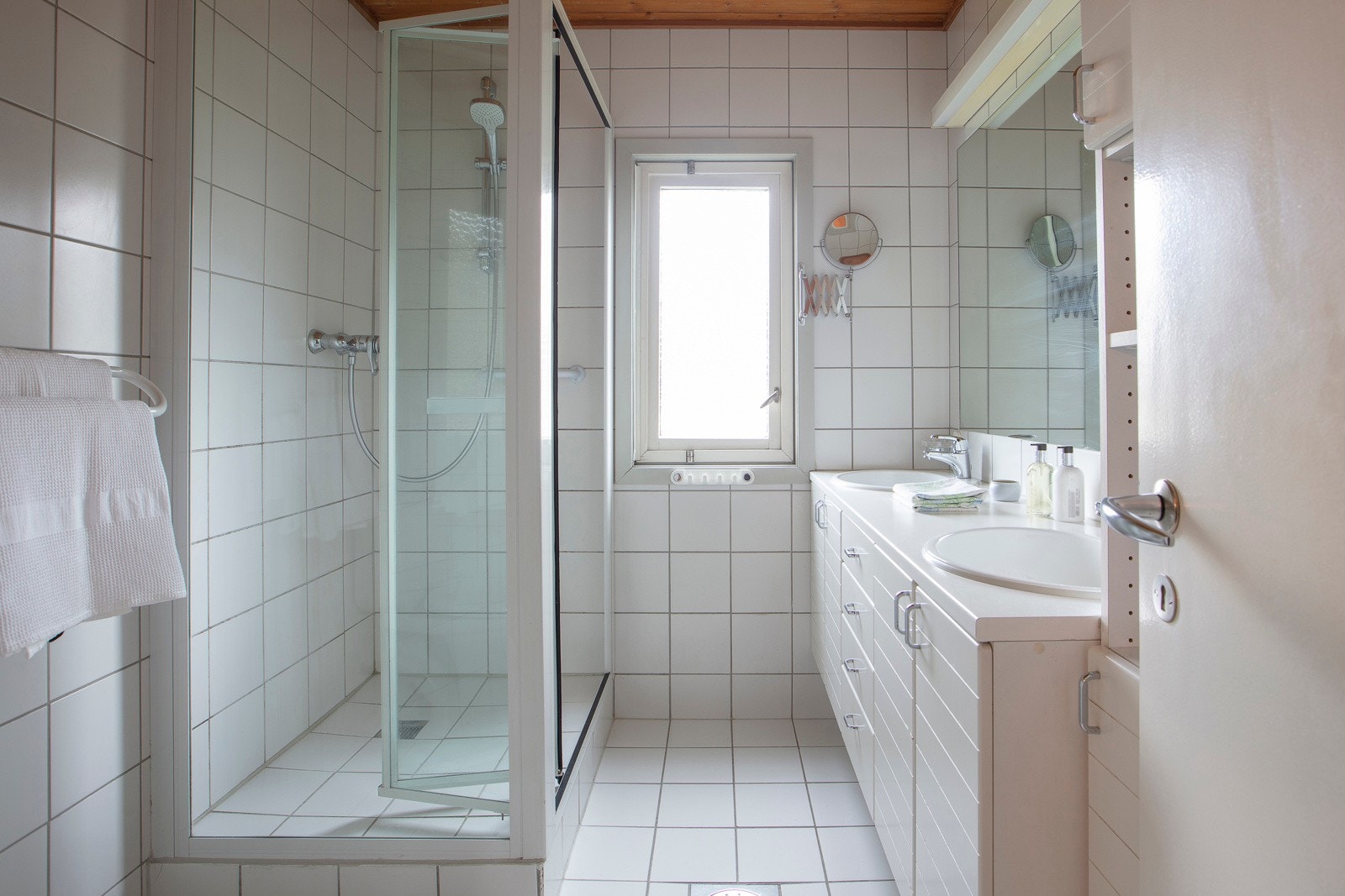 Det flislagte badet er innredet med dusjnisje, toalett, servant med innredning og speil. Her er det også varme i gulv. Fra entréen har du også tilgang til gjestetoalett. Galleribilde