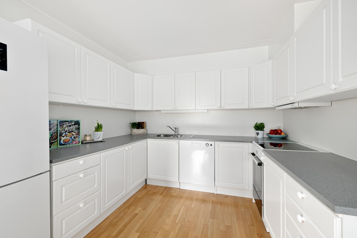 Lyst og romslig kjøkken med rikelig med skap- og benkeplass Galleribilde