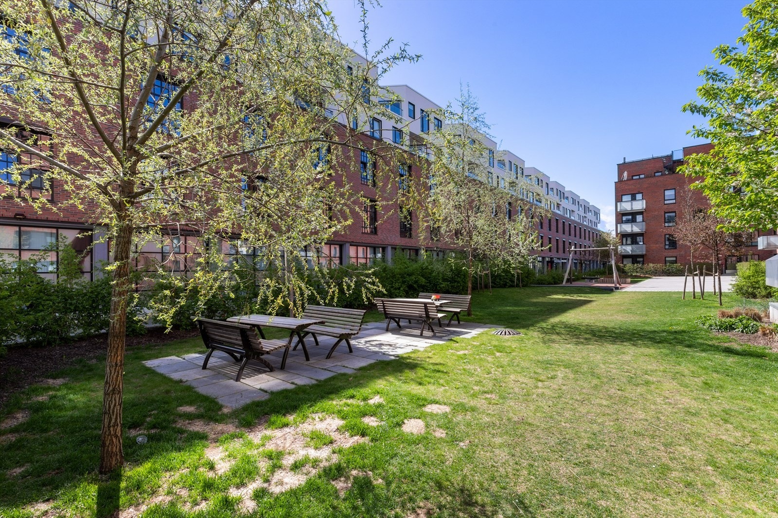 Rett utenfor døren finnes grøntarealer med sittegrupper, lekeapparater m.m. Galleribilde