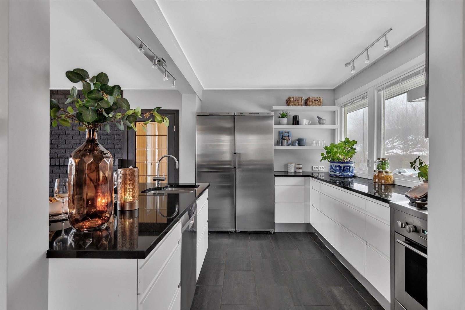 Lekkert HTH kjøkken med glatte fronter og benkeplate av sort granitt Galleribilde