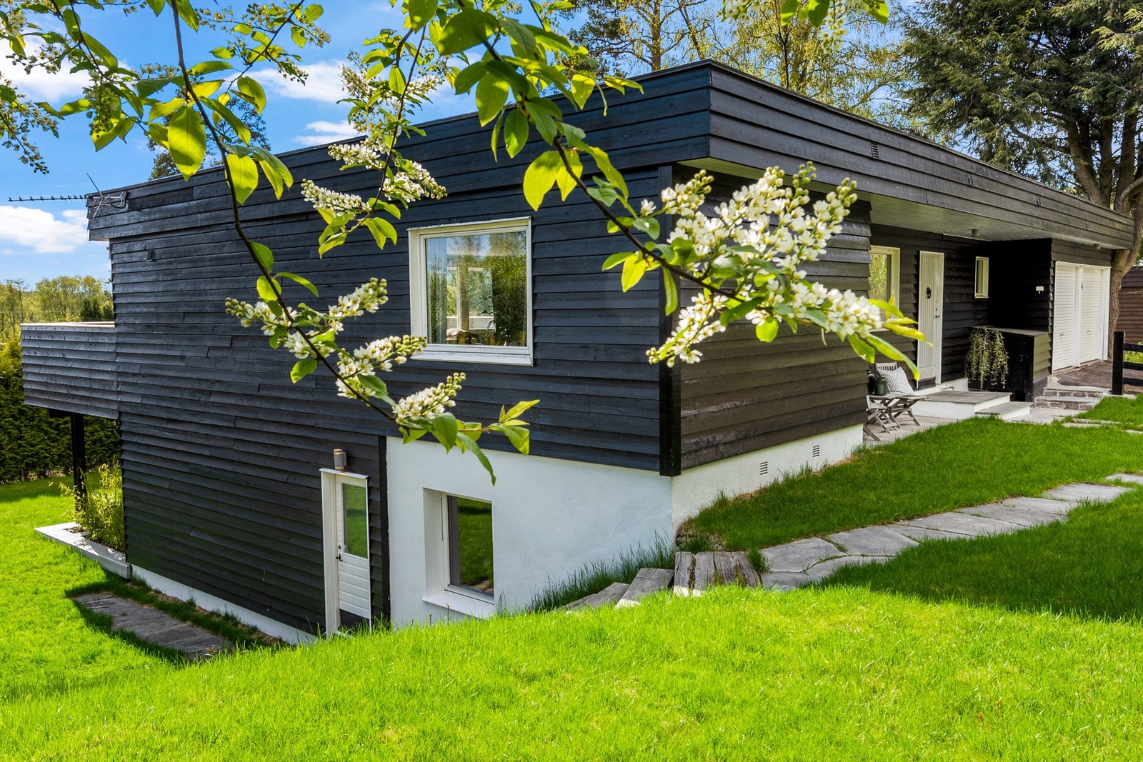 Eiendommen strekker seg over 2 nivåer med fin beplantning og gressplen på alle sider. Flotte utesoner på begge sider av huset. Underetasjen har også egen inngang. Galleribilde