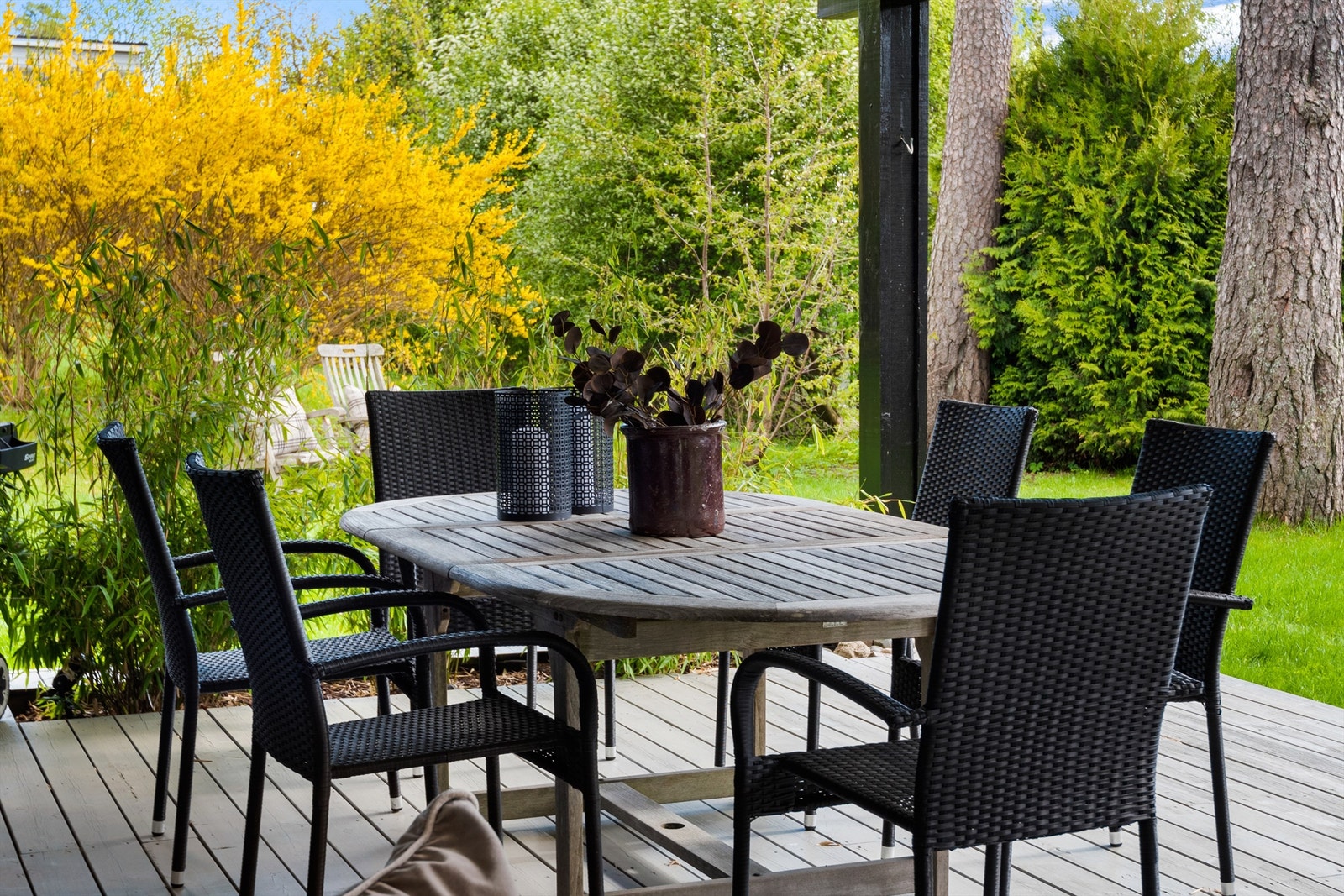Grønt, hyggelig, pen beplantning og solrikt er stikkord for terrassen Galleribilde