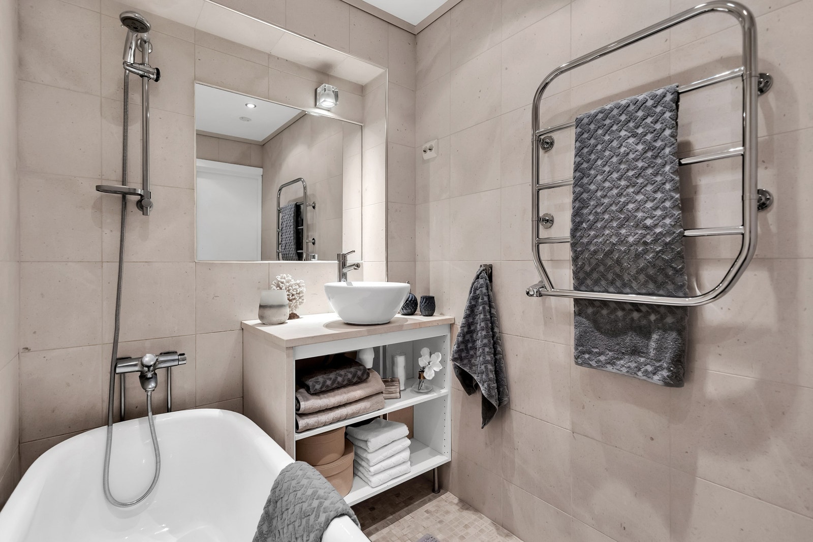 Badet har oppbevaringsmuligheter i servantskap og elektrisk håndkletørker Galleribilde