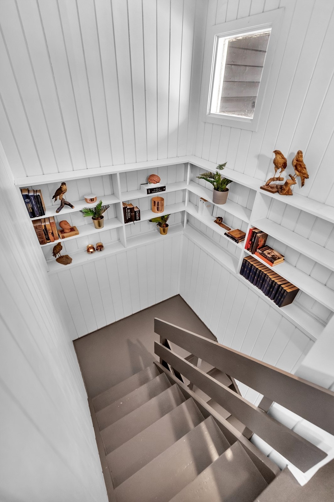 Hyggelig trappegang med bokhyller på veggene. Vinduet gir behagelig lys i trapperommet. Galleribilde