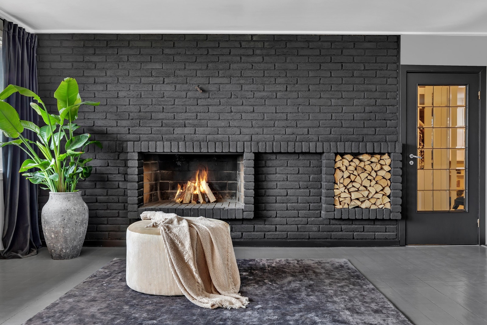 Original teglsten er blitt malt om i dempet sort. Dette gir peisen et flott uttrykk i stuen. Galleribilde