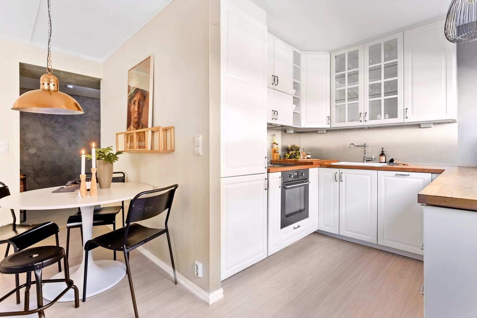 Kjøkkenet består av innredning med lakkerte 1-speils profilerte fronter, 2 stk. glassfronter i overskap, laminat benkeplate med sprutplate over, enkel oppvaskkum, kjøkkenventilator i stål, integrert koketopp, stekeovn, oppvaskmaskin og kjøl-/fryseskap Galleribilde