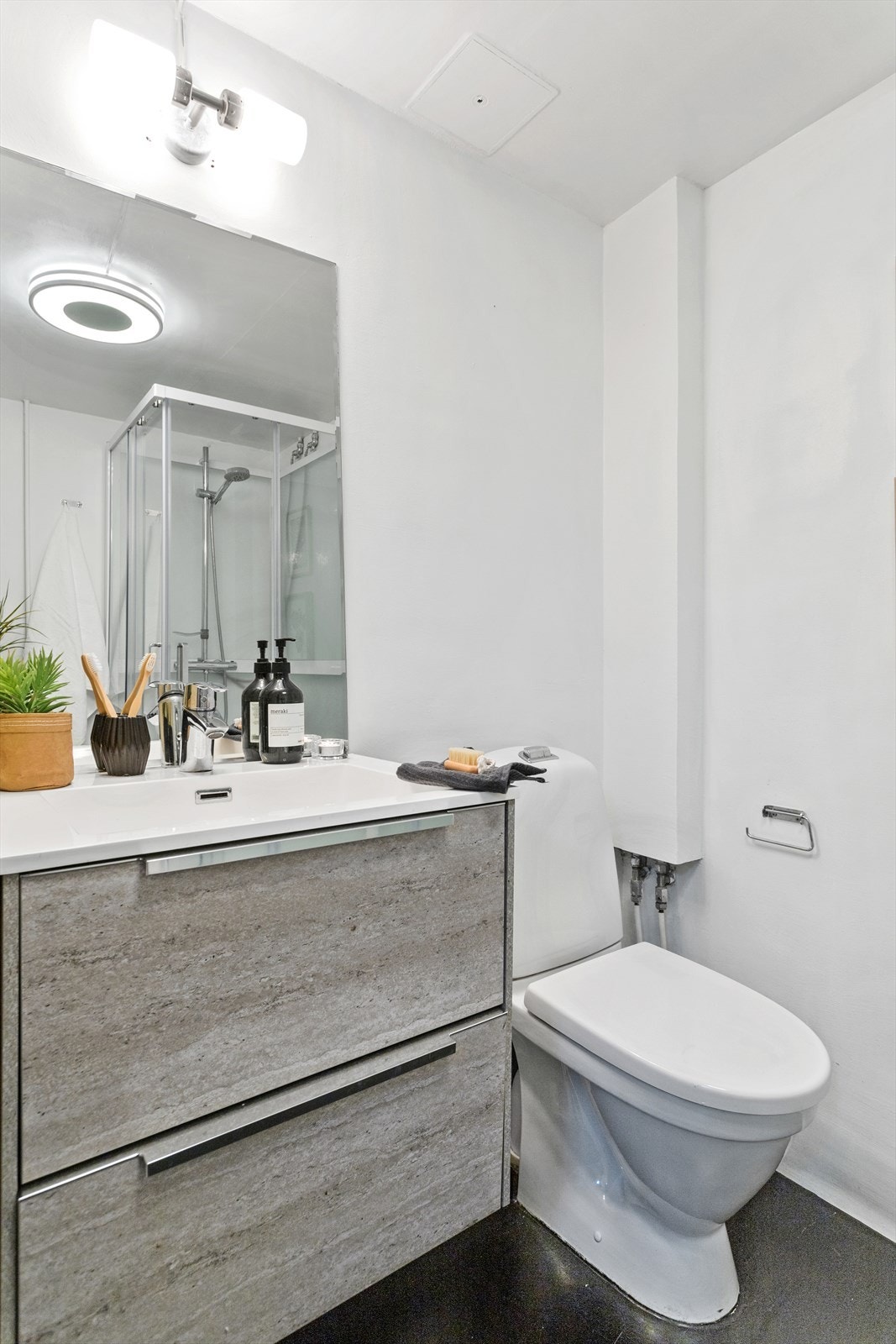 Badet består av frittstående toalett, servant med underskap, speil med overlys, dusjkabinett og opplegg for vaskemaskin (Vaskemaskin medfølger) Galleribilde