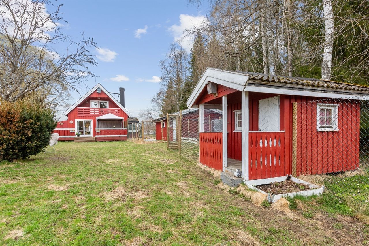 Fasade, og hage med garasje og lekestue. Galleribilde