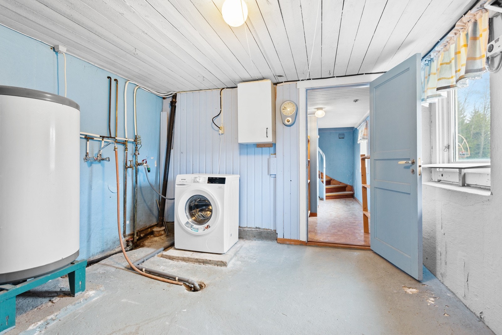 I kjelleren ligger også boligens romslige vaskerom med malt betonggulv og murvegger i lyseblått. Galleribilde