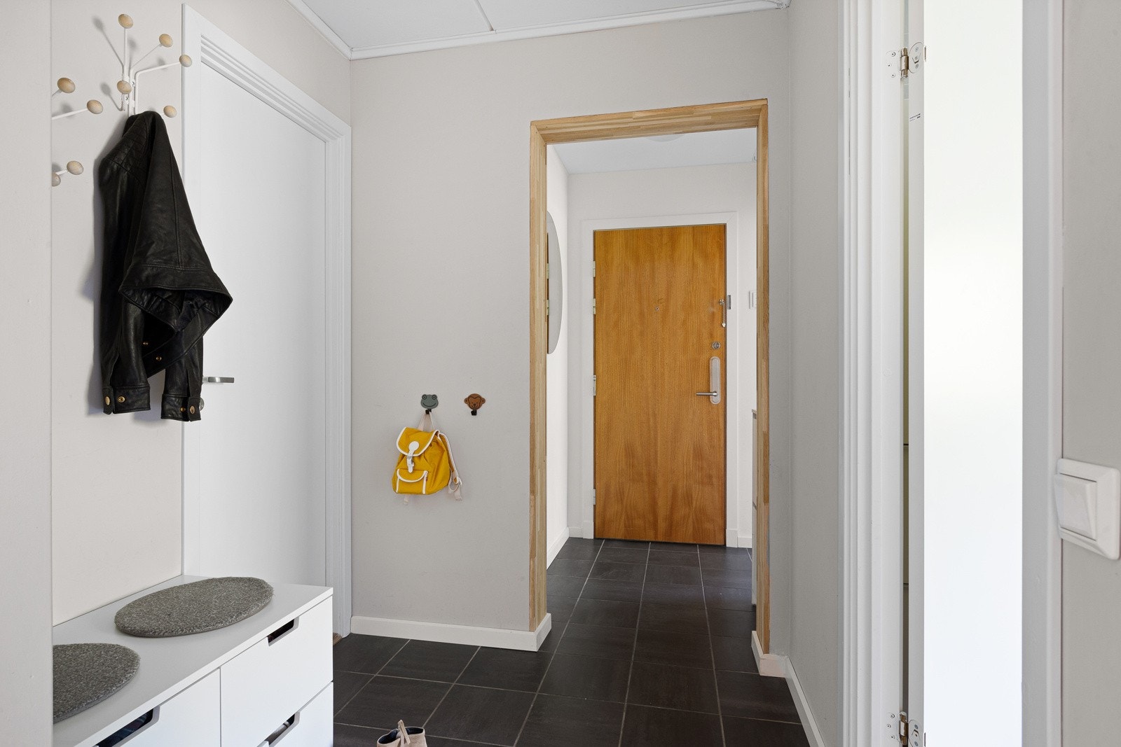 Lys og fin entré med flislagt gulv. Det er bestilt ny entrédør med estimert levering juni 2021. Galleribilde