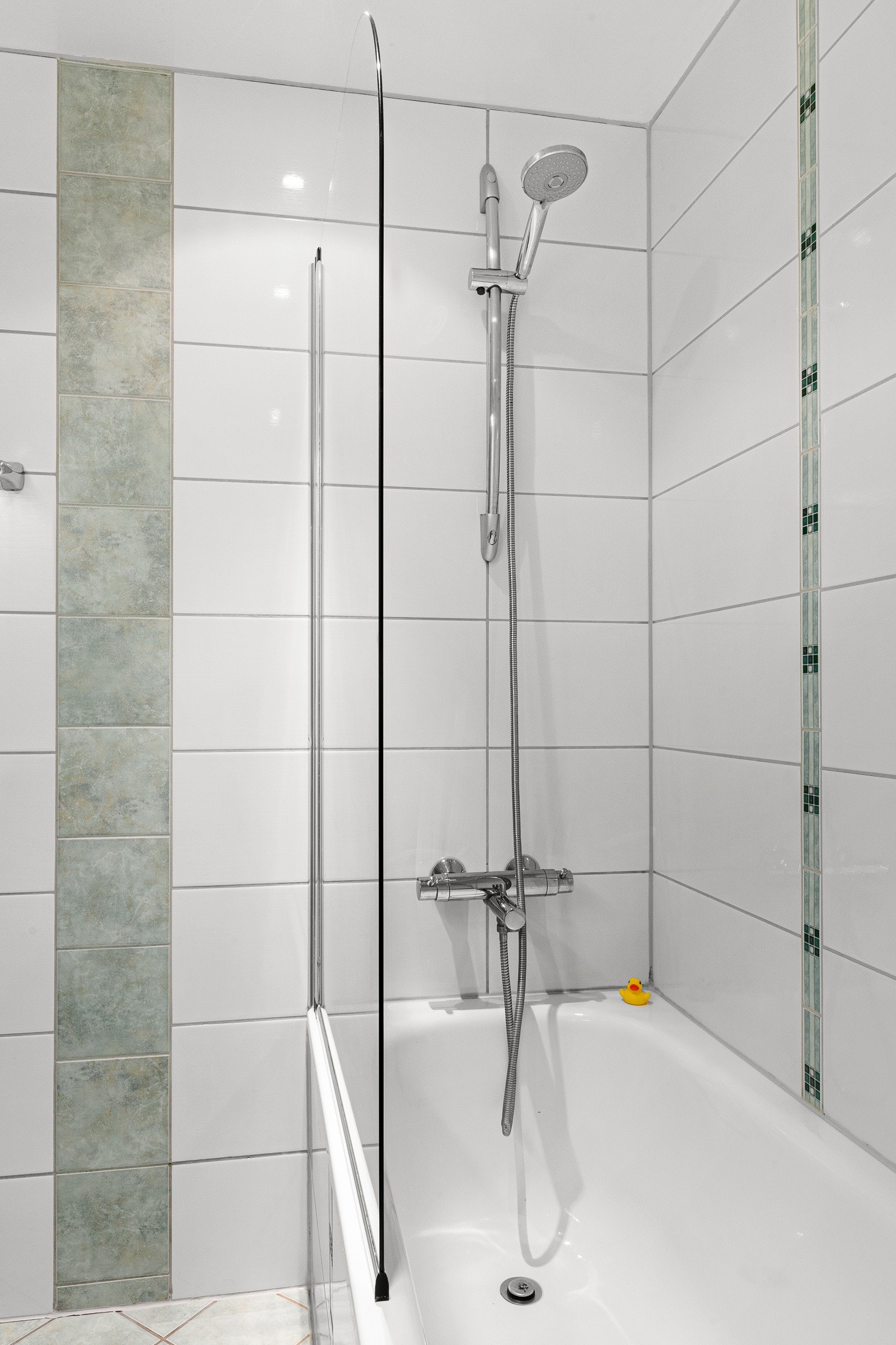 Flislagt badekar med delvegg av glass. Galleribilde