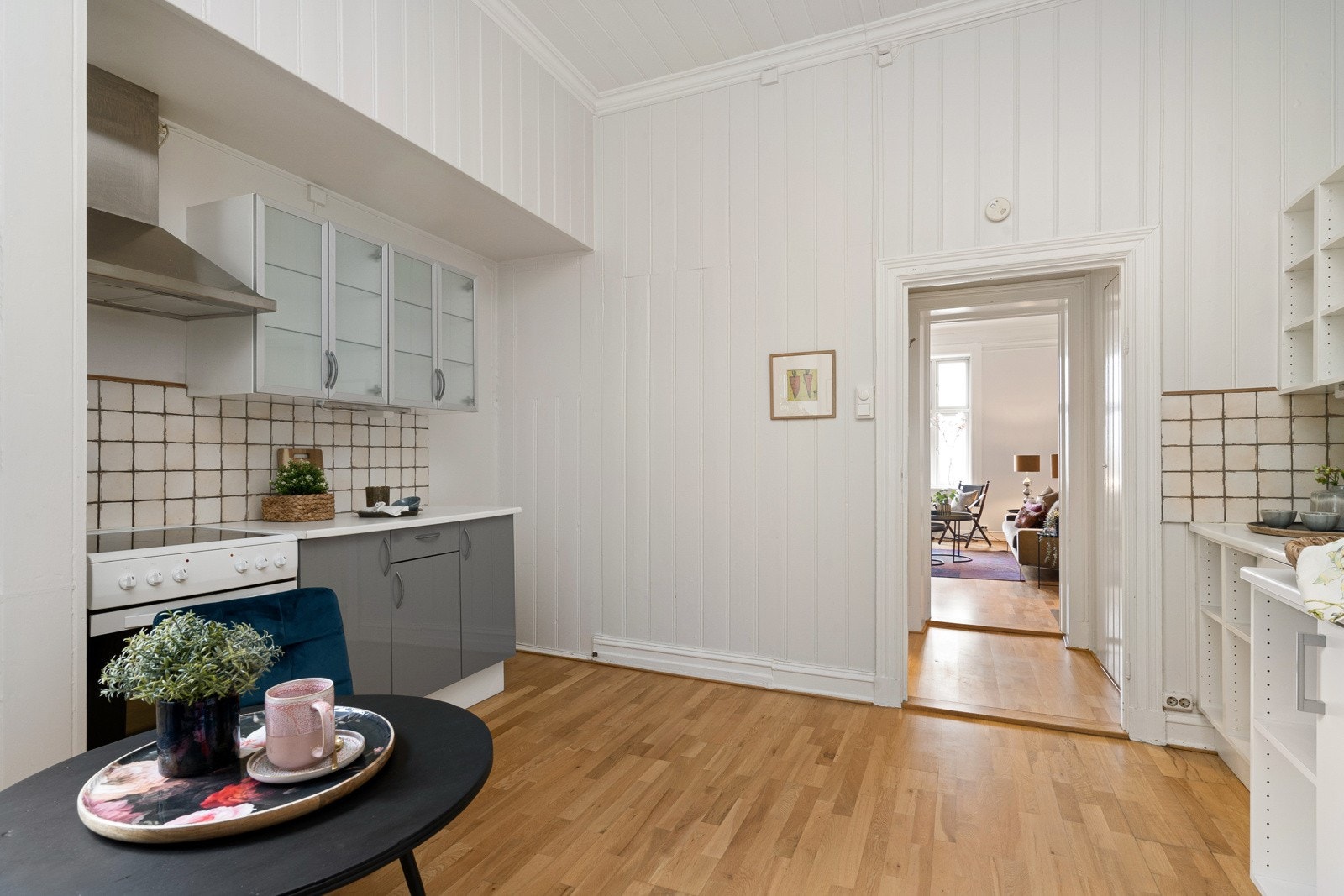 Kjøkkenet har trestavs parkett, malt trepanel på vegger og i tak, samt adkomst til bod og en gang mot baktrappen. Galleribilde