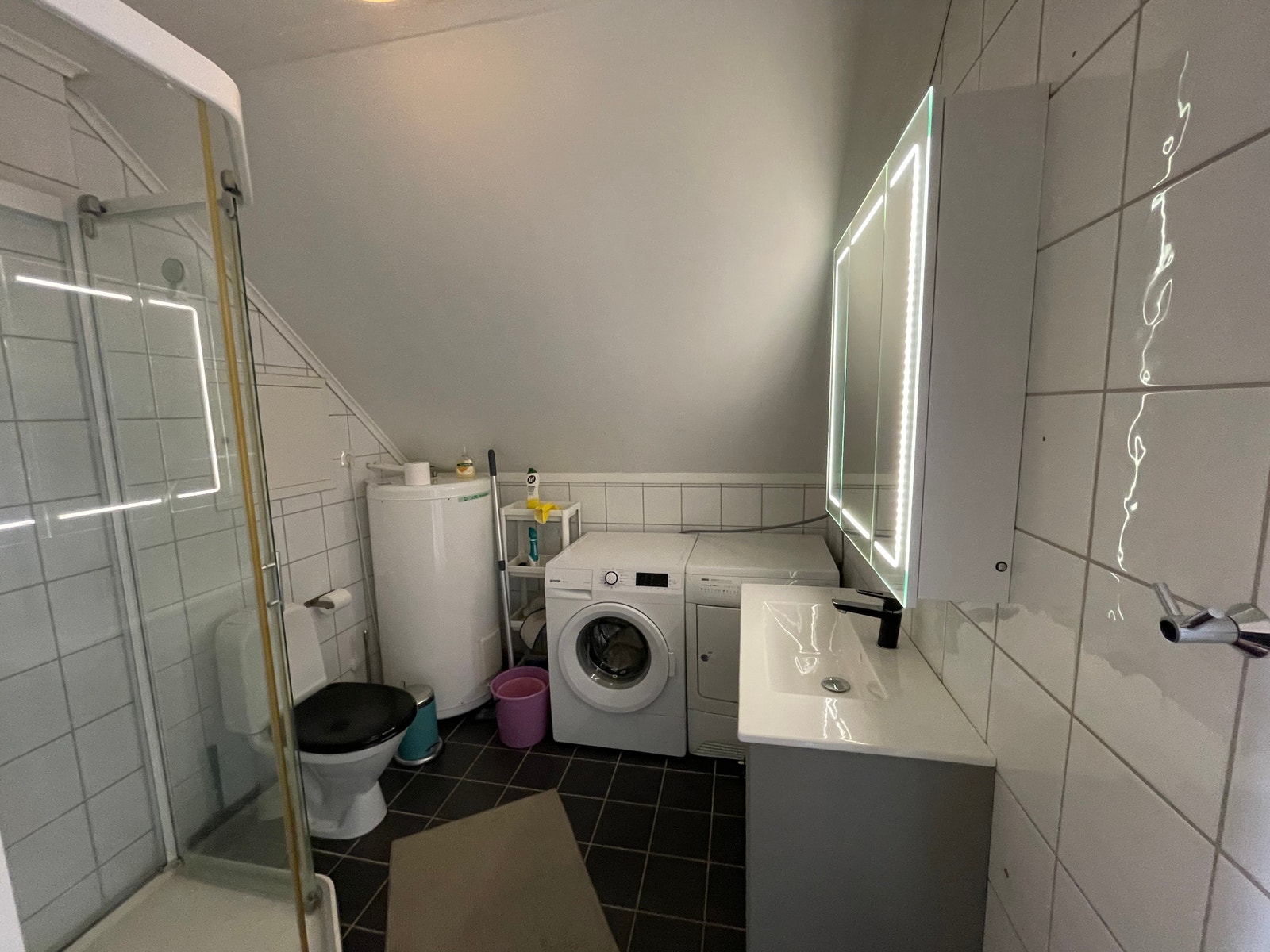 Bad med dusjkabinett, vaskemaskin og tørketrommel Galleribilde