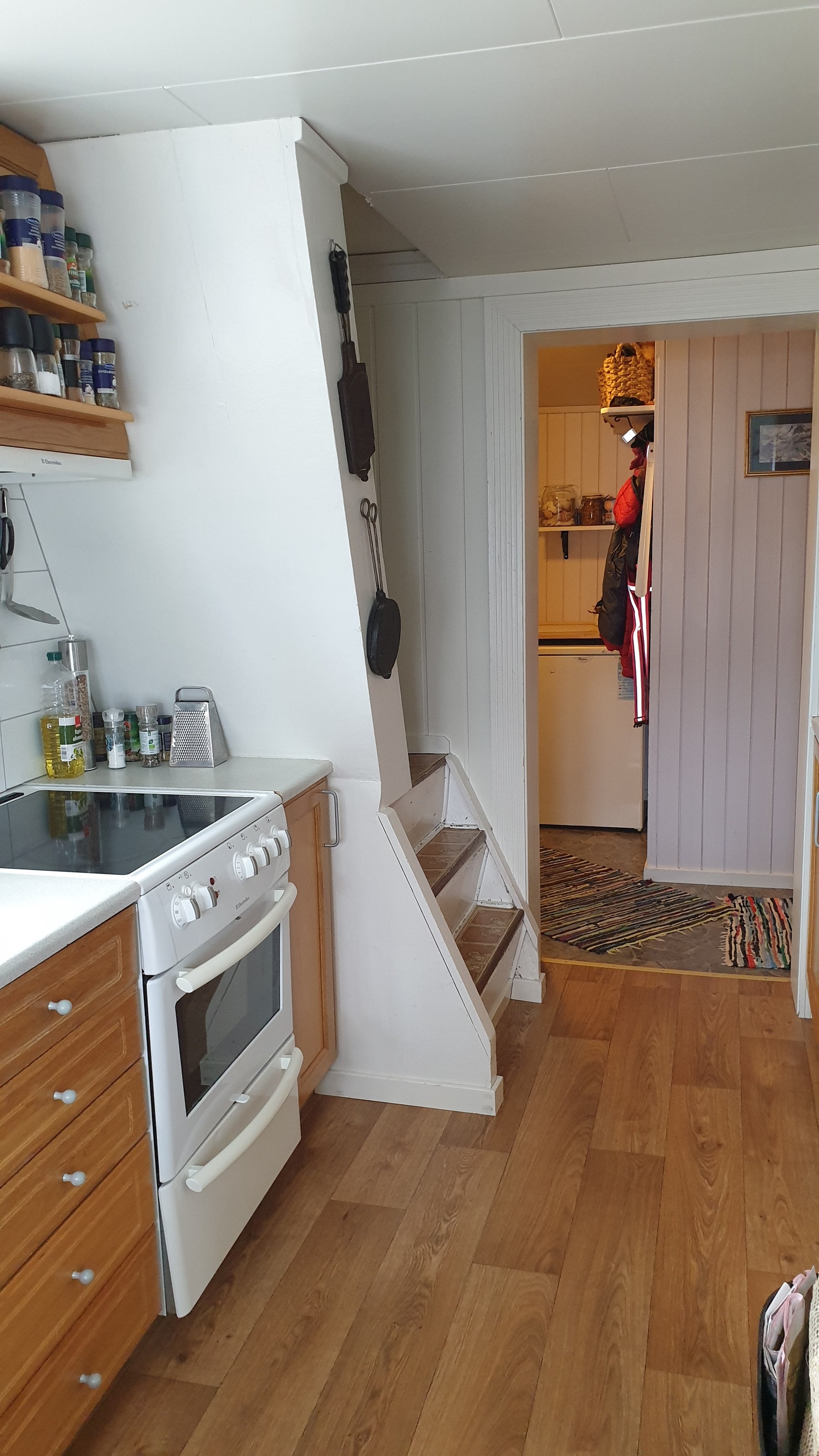 Kjøkken med trapp opp til loft. Kjøleskap og fryseboks er plassert i gangen for å få bedre utnyttelse av plassen på kjøkkenet. Galleribilde