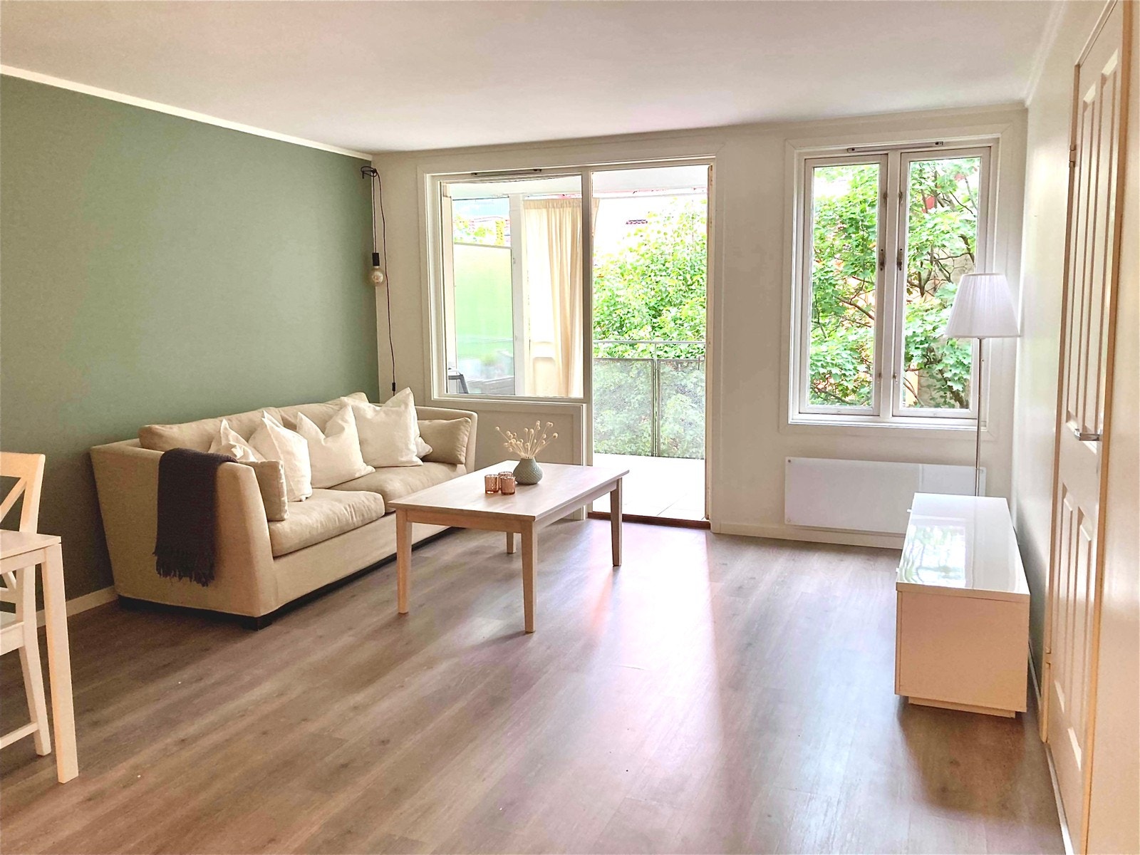 Romslig og lys stue med store vinduer og utgang til balkong. Galleribilde