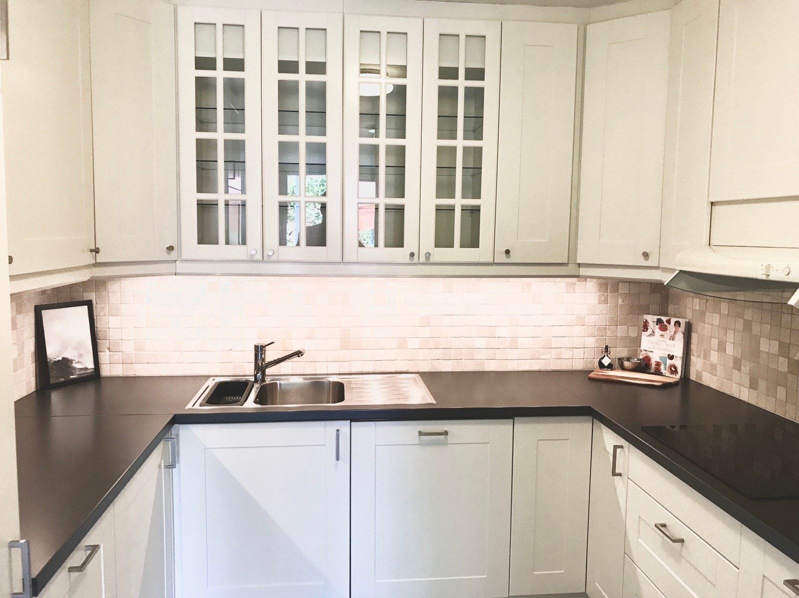 Stort kjøkken med mye benkeplass for den som er glad i å lage mat. De hvite frontene står i stil med resten av leiligheten og binder det hele sammen i et lyst og moderne utseende. Galleribilde