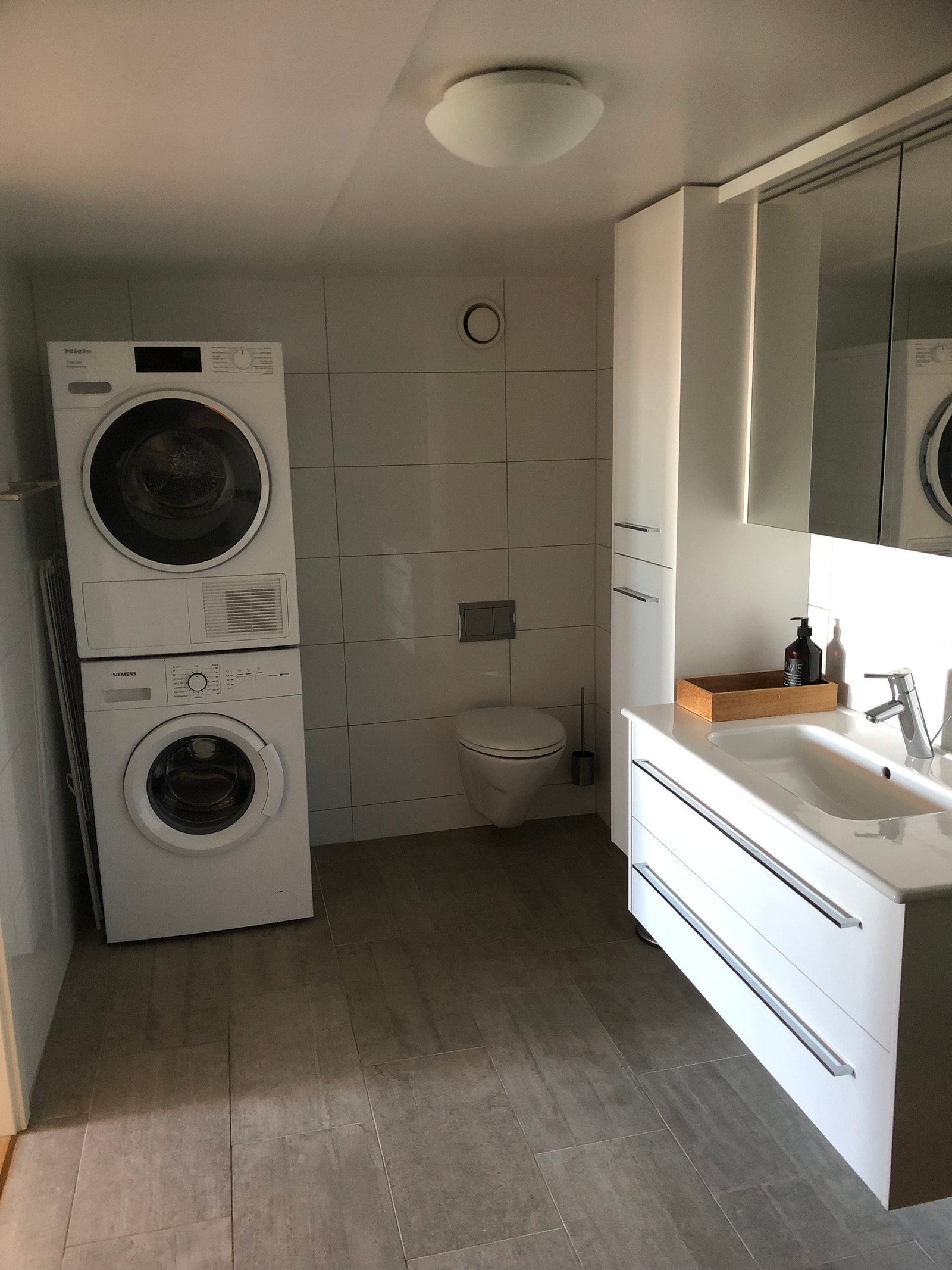 Stort romslig moderne bad med god skapplass, vaskemaskin og tørketrommel. Galleribilde