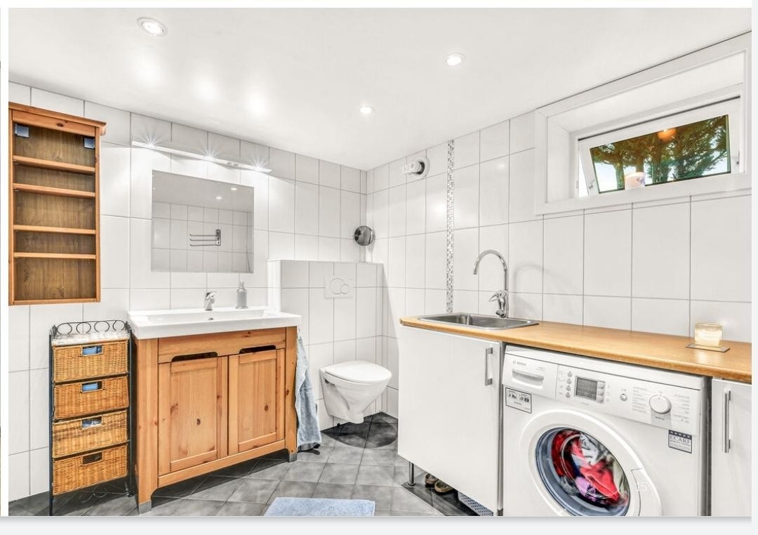 Bad/vaskerom med vaskemaskin og stor dusjhjørne Galleribilde