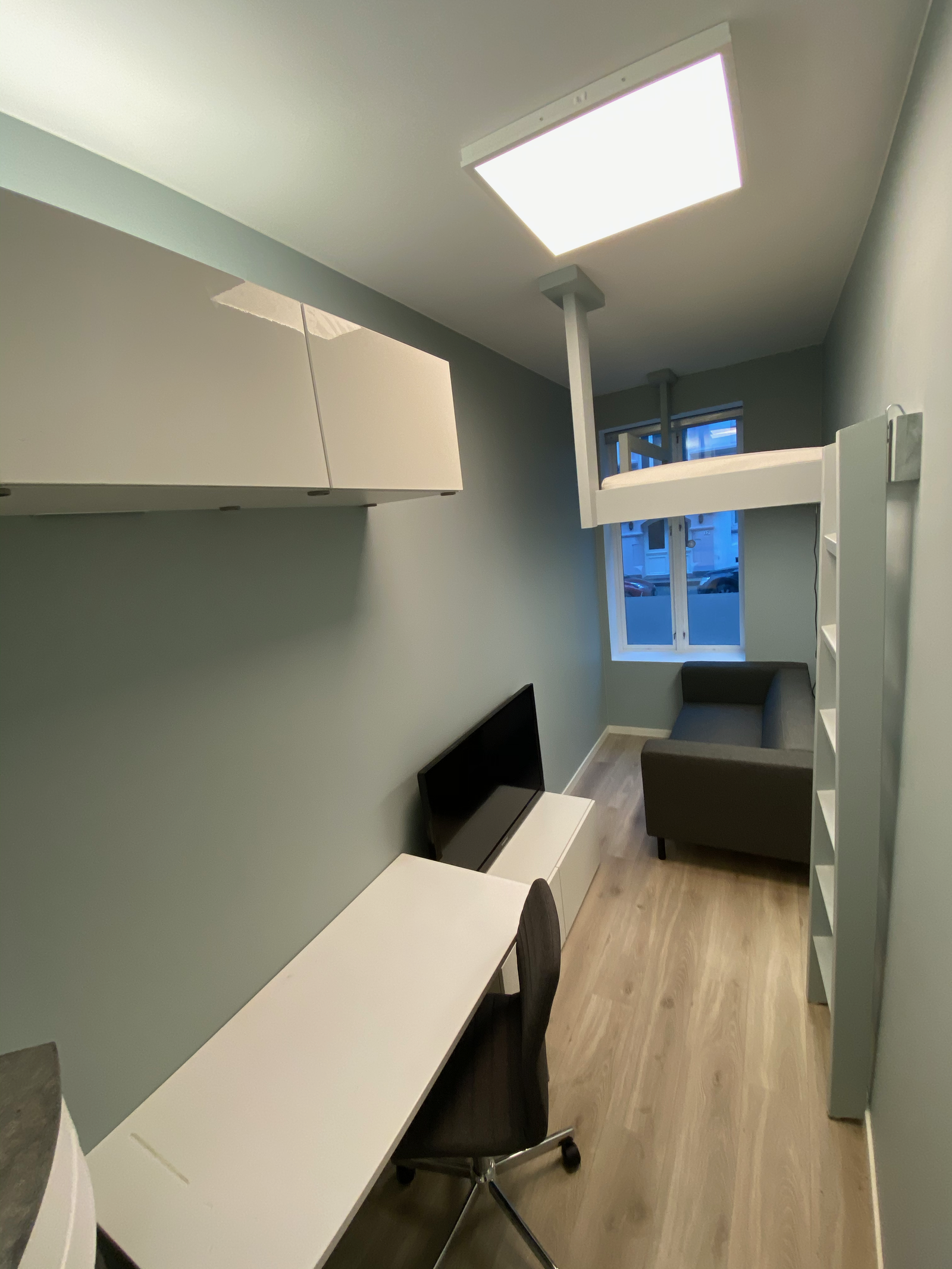 Oppbevaring, skrivepult, tv og sofa i rom #2 Galleribilde