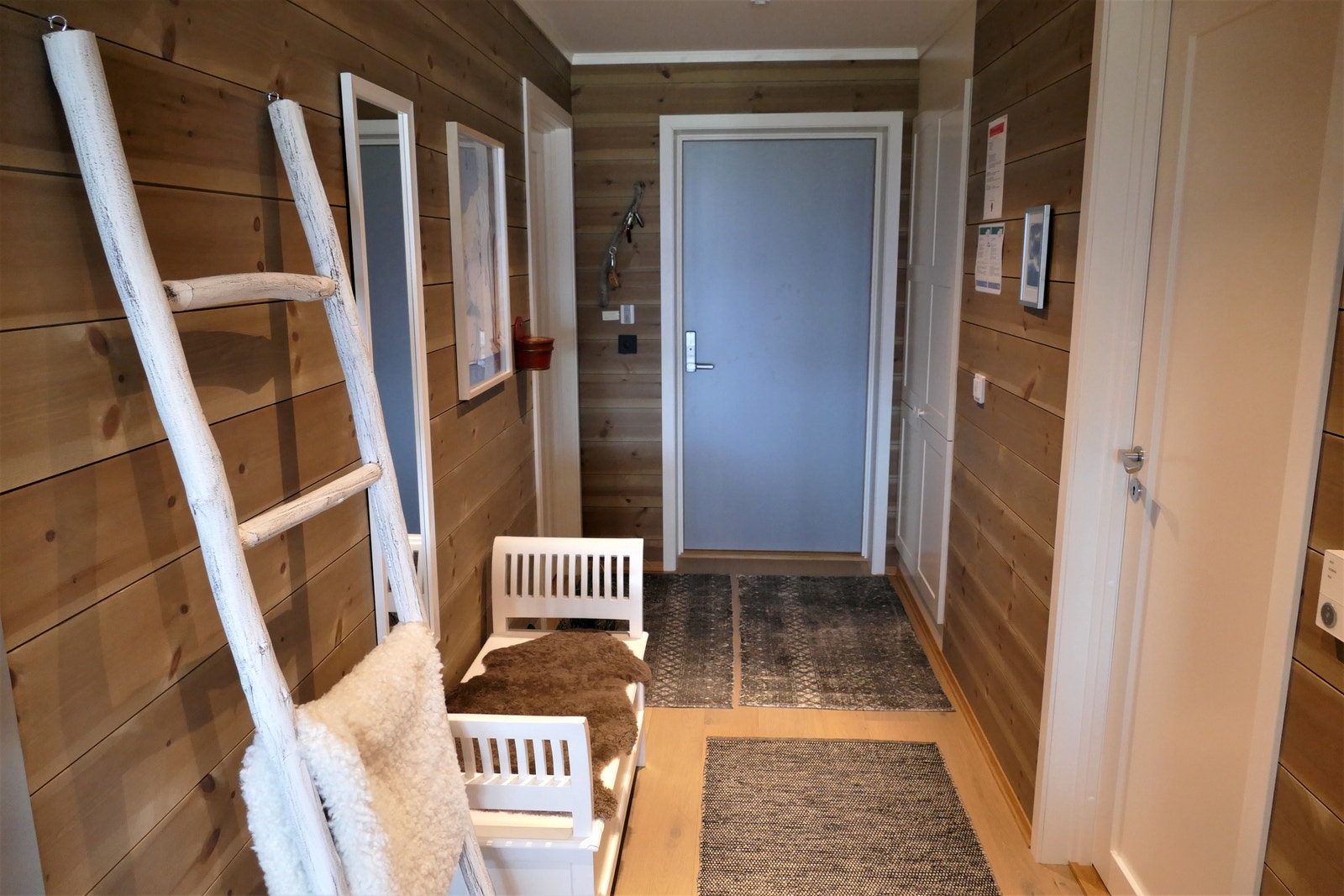 Hyggelig entre med benk, speil og stort garderobeskap Galleribilde