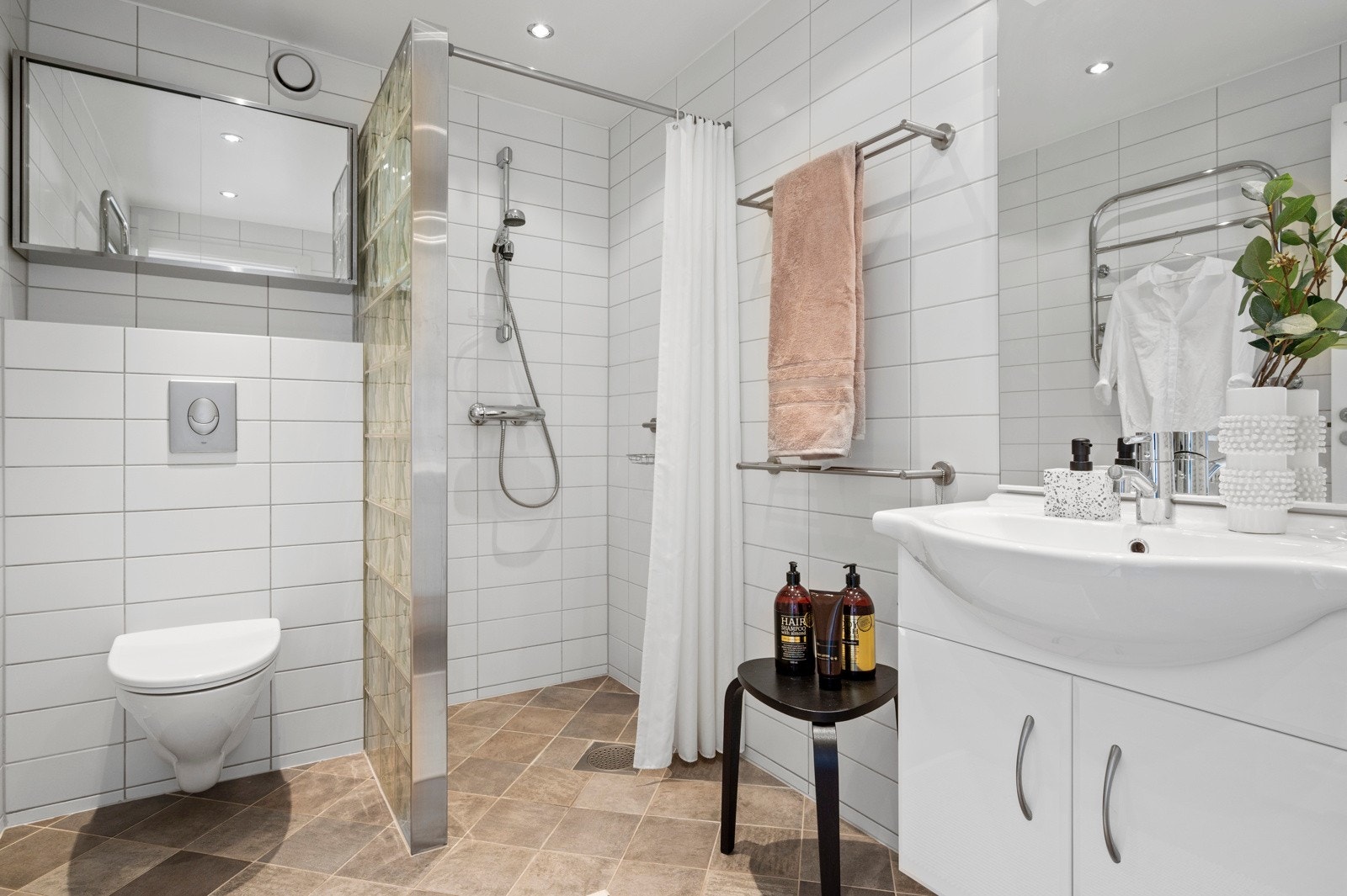 Delikat flislagt dusjbad med varmekabler i gulv og downlights i himling. Galleribilde